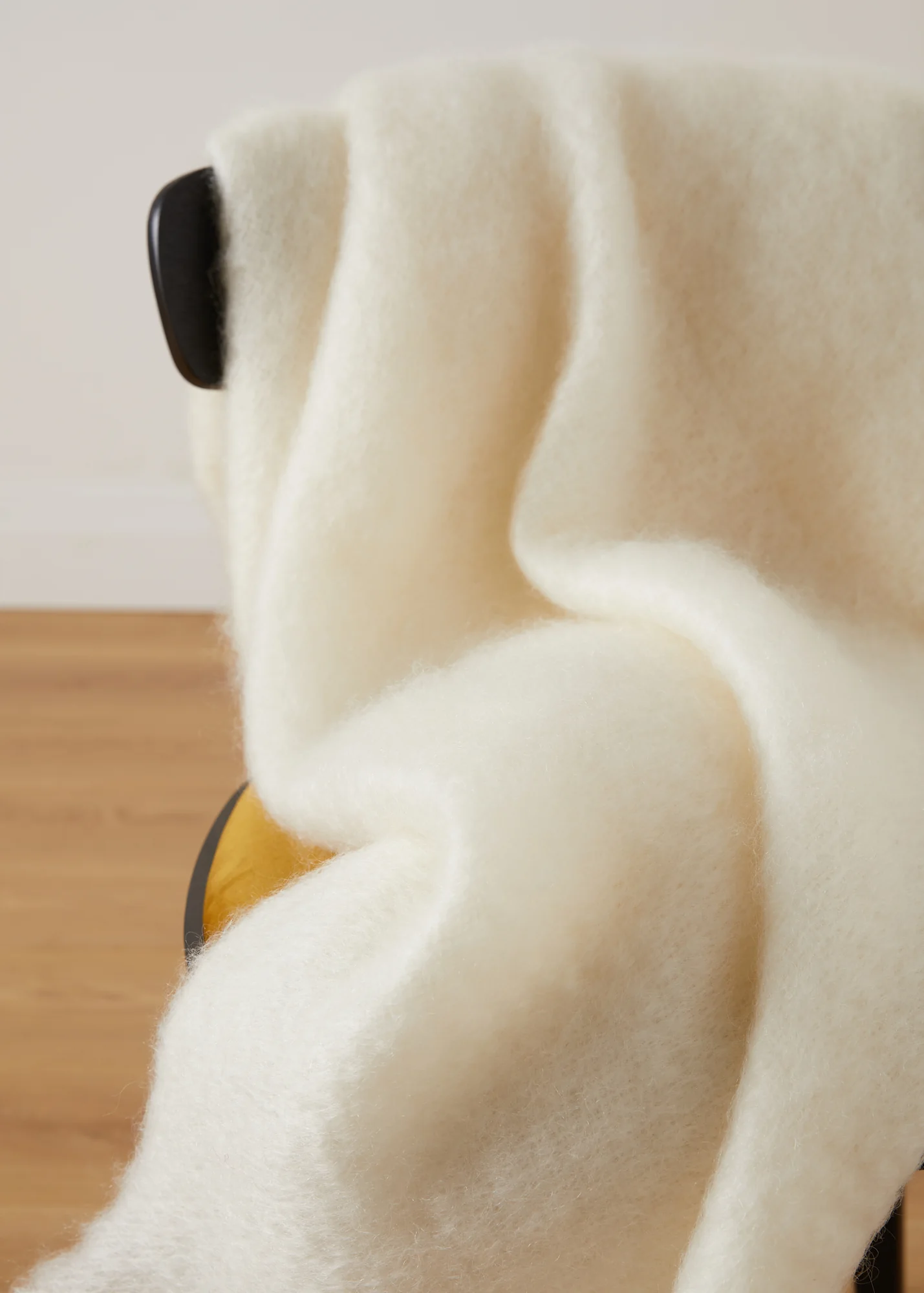 Detail der flauschigen Struktur einer Mohairdecke in Cremeweiß und Naturweiß