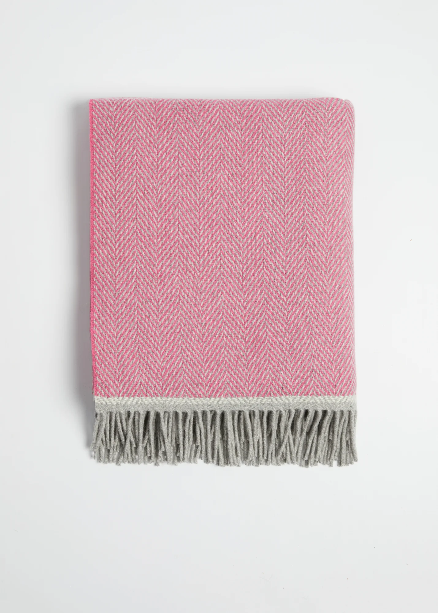 Wolldecke Croía aus Naturfasern mit Rollfransen in Rosa und Grau