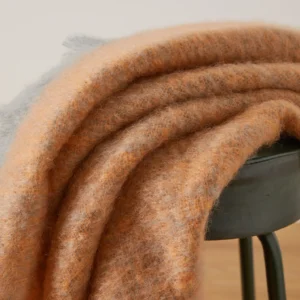 Mohairdecke Causeway in Apricot und Salbeigrün auf Sofa oder Sessel drapiert