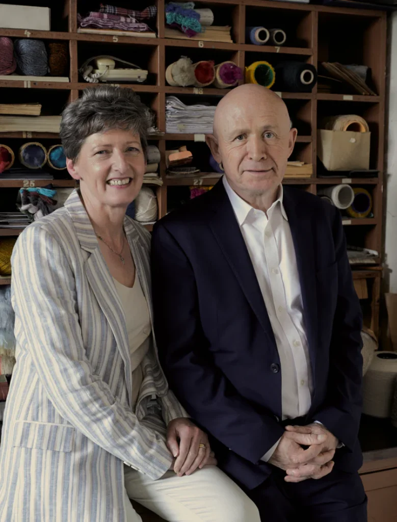 Die heutigen Eigentümer von FOXFORD Woollen Mills vor historischen Wollgarnen und Archivregalen in der Weberei